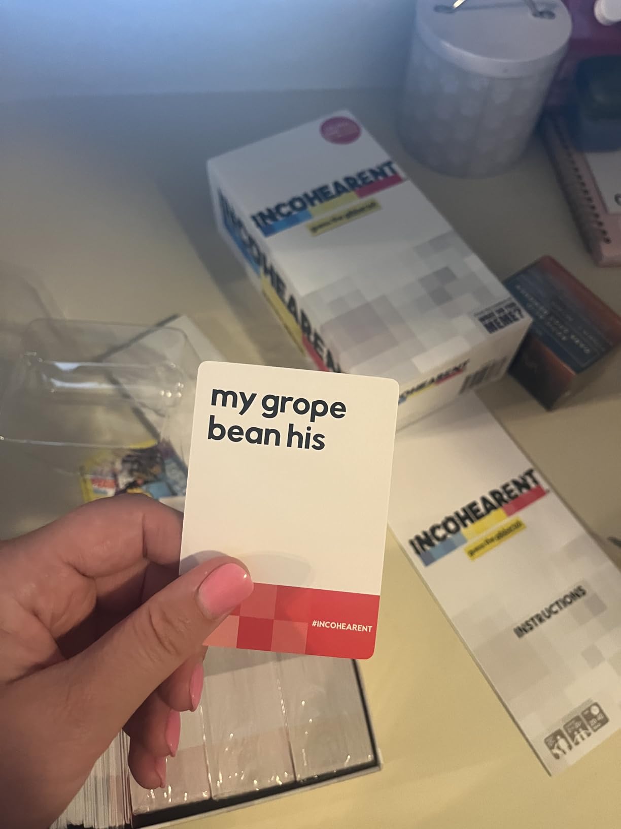 Incohearent card held up next to the open box and instructions